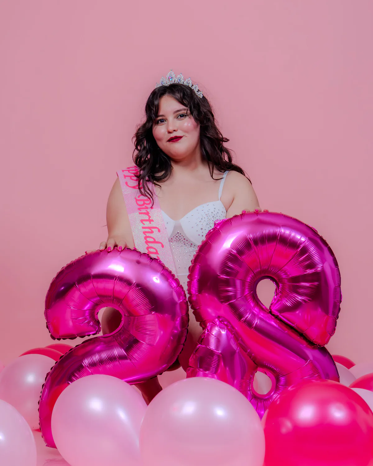 Nina celebrando con globos fucsias y rosas